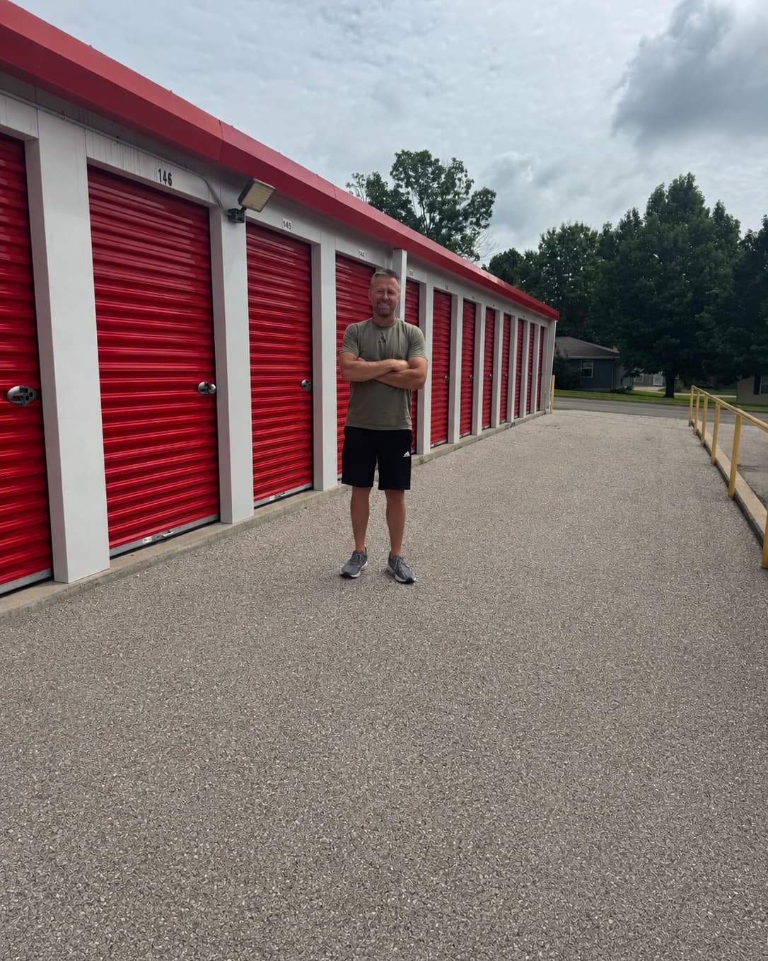 Kenny Buelterman standing in front of the red roll-up doors at one of his storage facilities